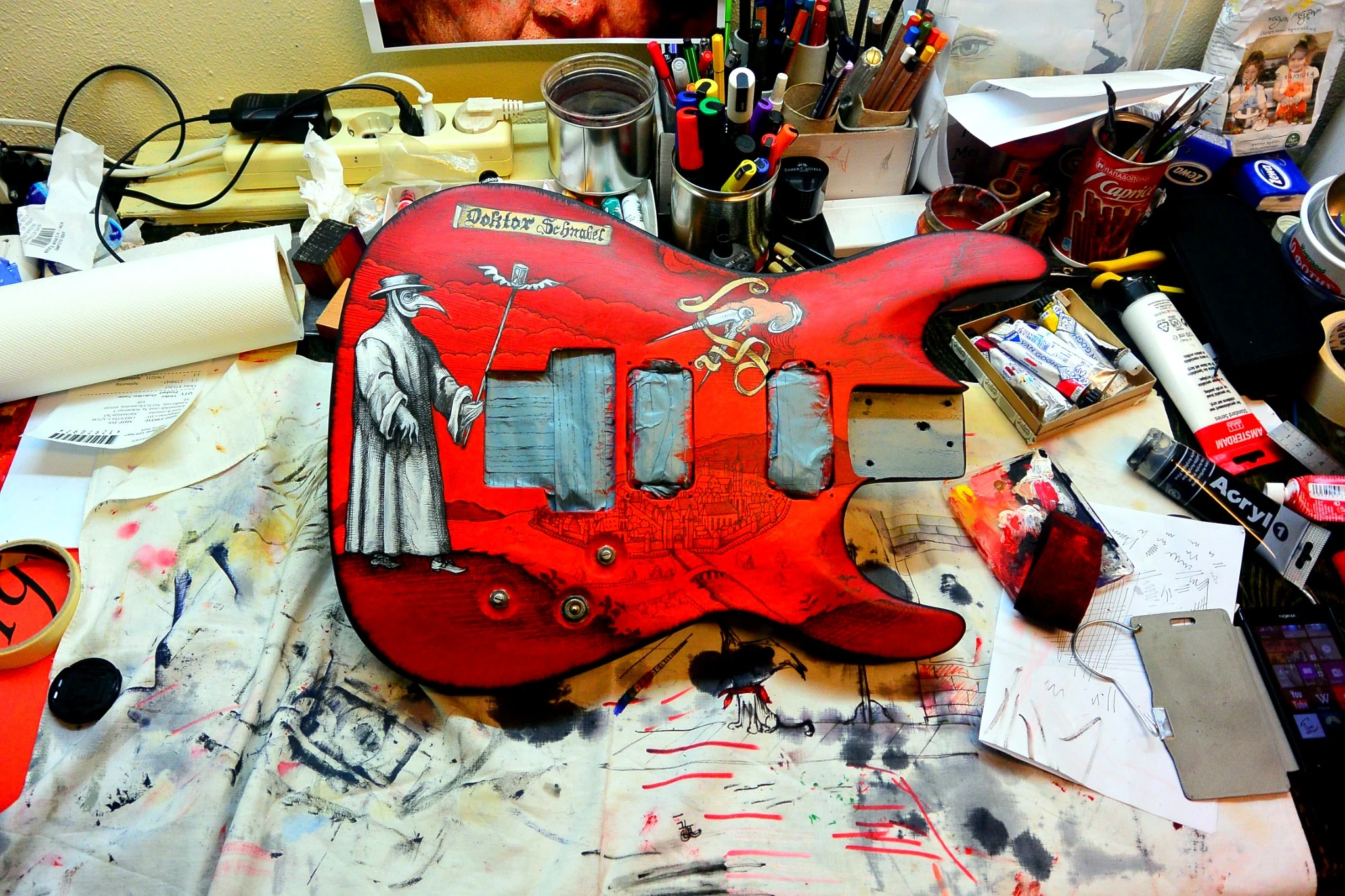 Dr. Schnabel guitar body being hand-painted on the artist’s workbench